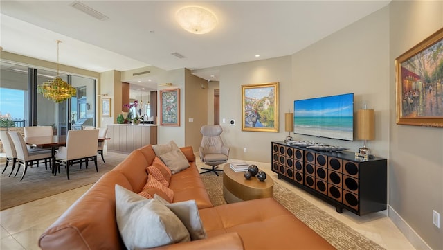 tiled living room with a notable chandelier