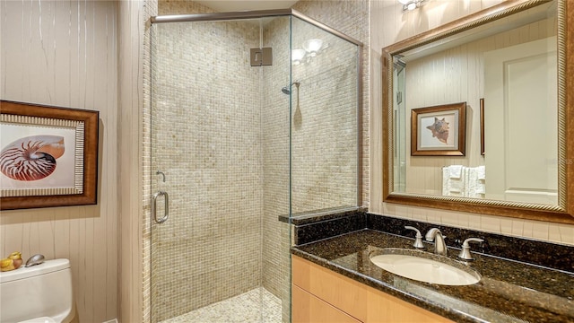 bathroom featuring vanity, an enclosed shower, and toilet