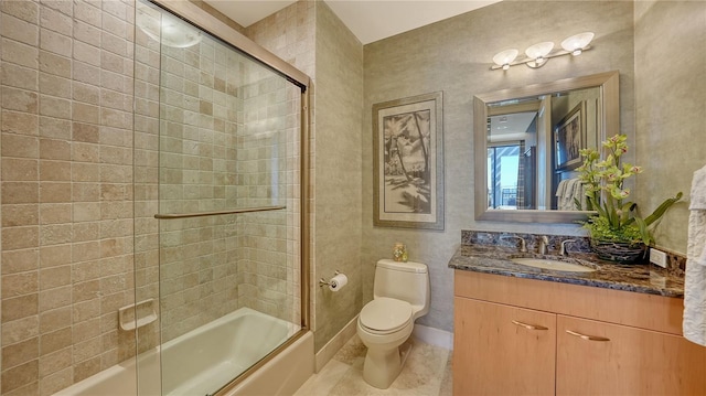 full bathroom featuring vanity, tile patterned flooring, shower / bath combination with glass door, and toilet