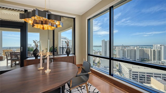 dining room with a water view, parquet floors, and a chandelier