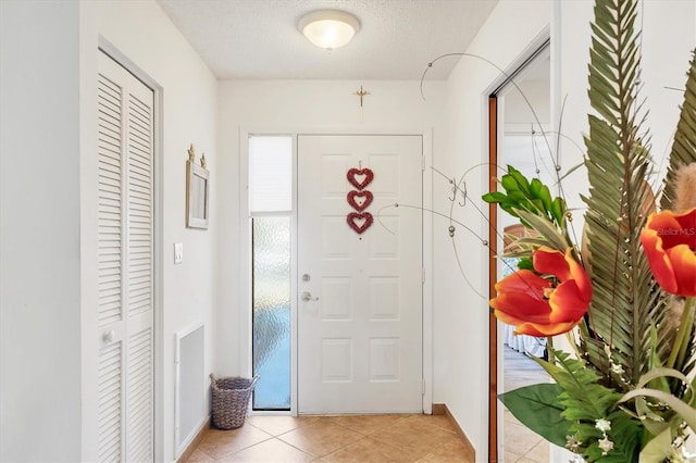 tiled foyer with a textured ceiling