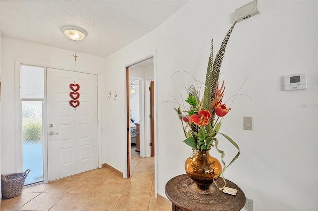 tiled entrance foyer with a textured ceiling