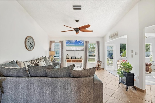 living room with light tile patterned floors, a textured ceiling, vaulted ceiling, and ceiling fan