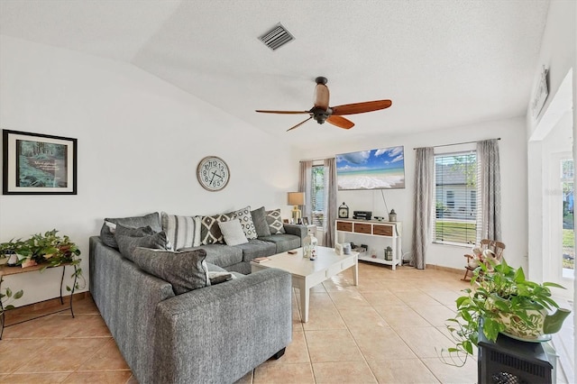 tiled living room with lofted ceiling, a textured ceiling, and ceiling fan