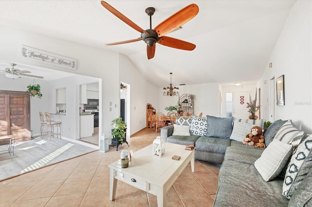 tiled living room with ceiling fan with notable chandelier and vaulted ceiling