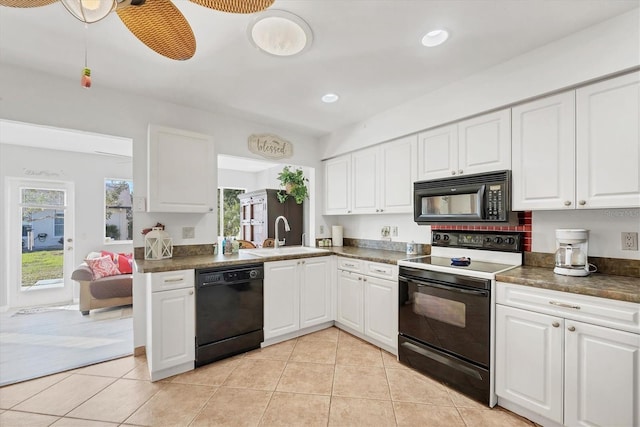 kitchen with sink, black appliances, light tile patterned floors, kitchen peninsula, and white cabinets