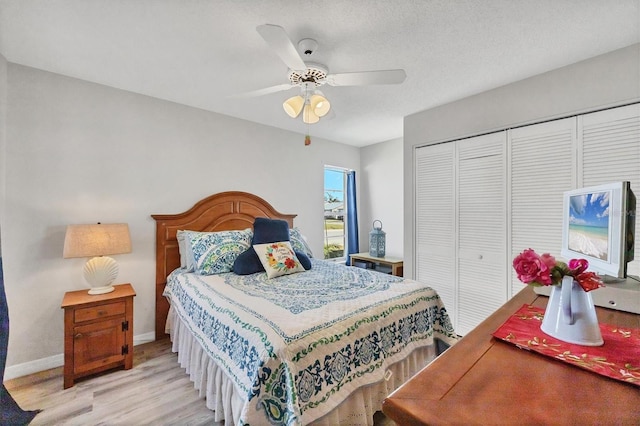 bedroom featuring a textured ceiling, a closet, ceiling fan, and light wood-type flooring