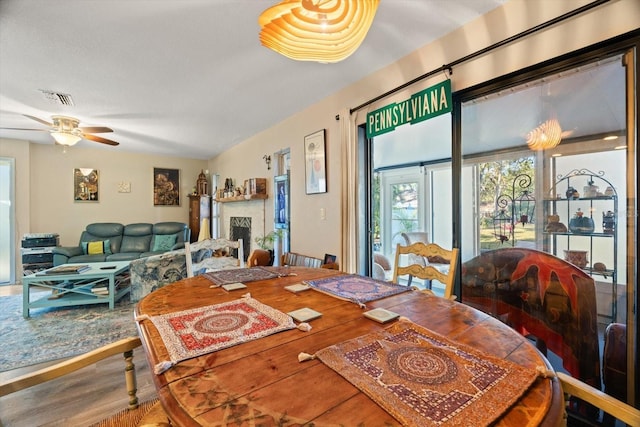 dining space featuring wood-type flooring and ceiling fan