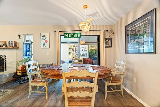 dining area with hardwood / wood-style floors and a fireplace