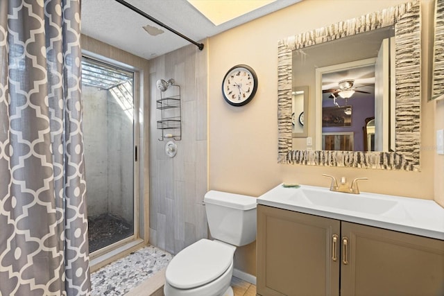 bathroom with ceiling fan, a shower with shower curtain, vanity, a textured ceiling, and toilet