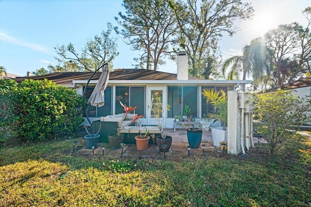 rear view of property with a yard, a sunroom, and outdoor lounge area