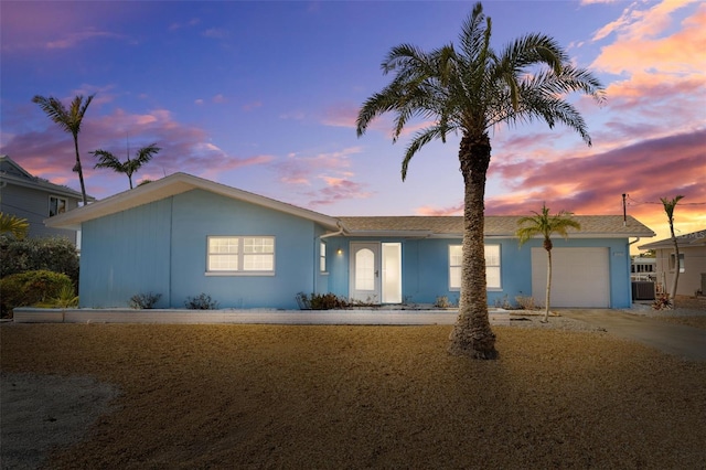 ranch-style home featuring cooling unit and a garage