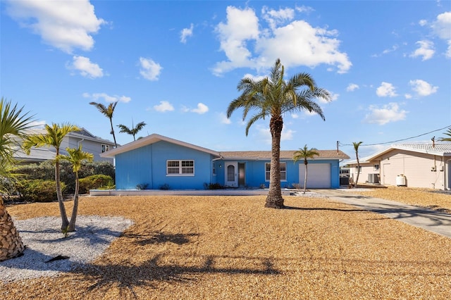 single story home featuring a garage and central air condition unit