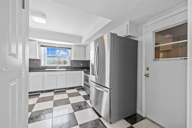 kitchen featuring tasteful backsplash, white cabinetry, appliances with stainless steel finishes, and sink