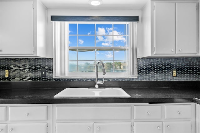 interior space featuring white cabinetry, sink, and decorative backsplash