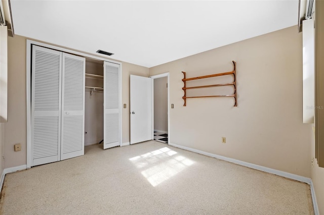 unfurnished bedroom with light colored carpet and a closet