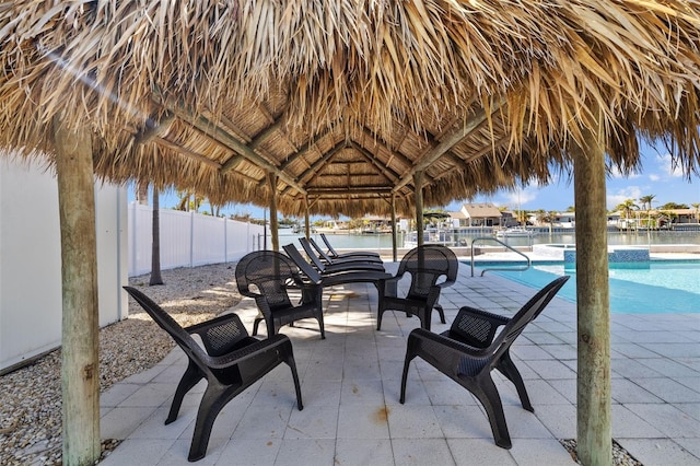 view of patio featuring a fenced in pool, a gazebo, and a water view