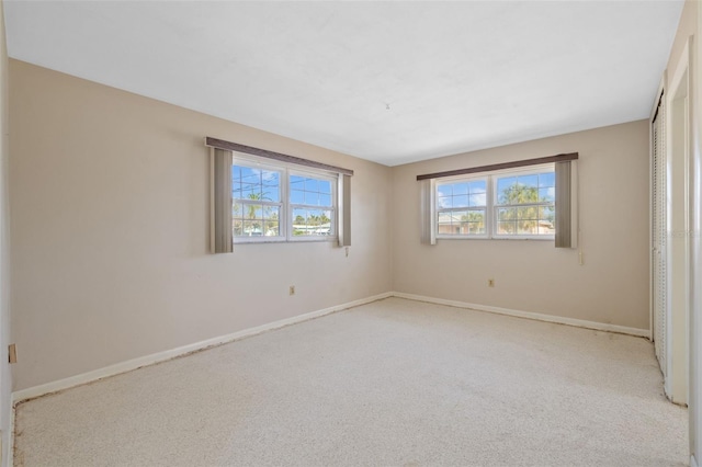 spare room featuring light carpet