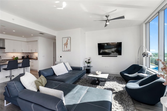 living room with hardwood / wood-style flooring, a wall of windows, and plenty of natural light