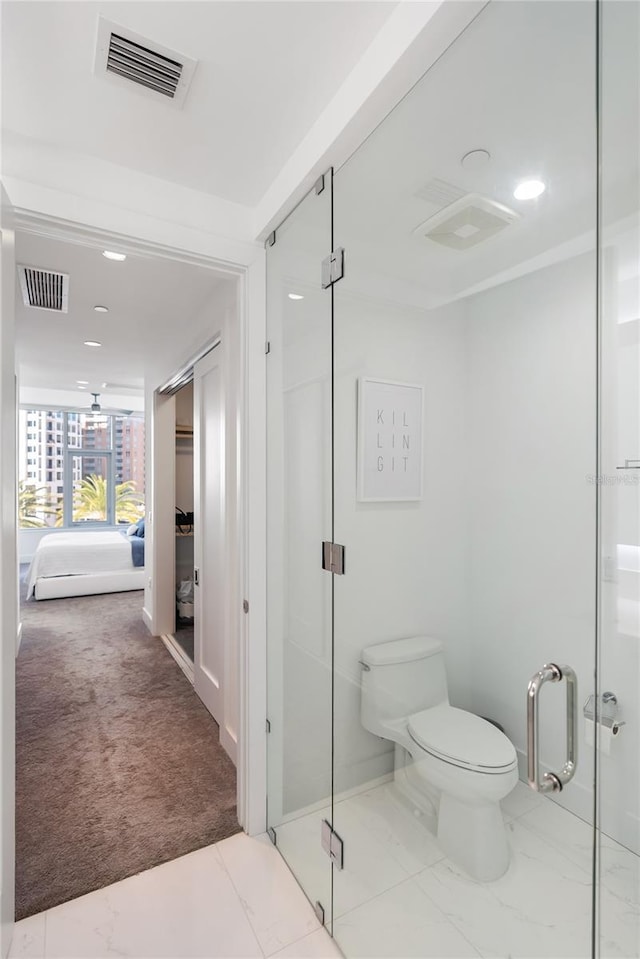 bathroom with an enclosed shower and toilet