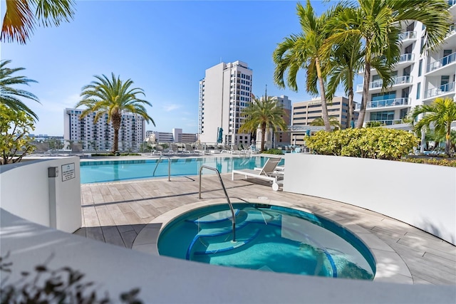 view of swimming pool with a patio and a community hot tub