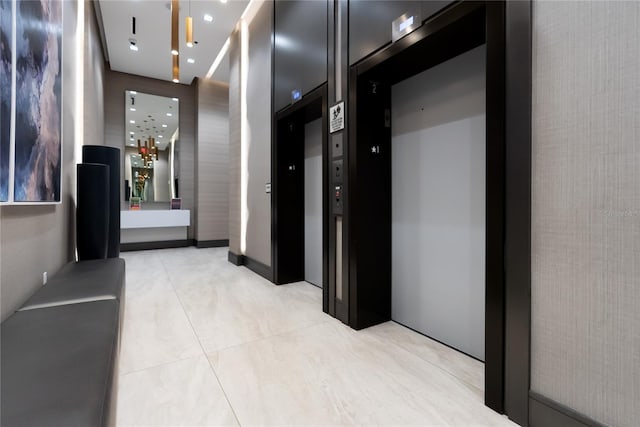 hallway with elevator and light tile patterned floors