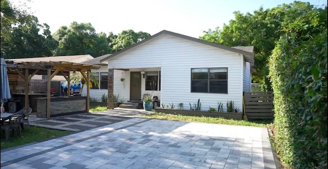 bungalow-style home with a pergola and a patio area