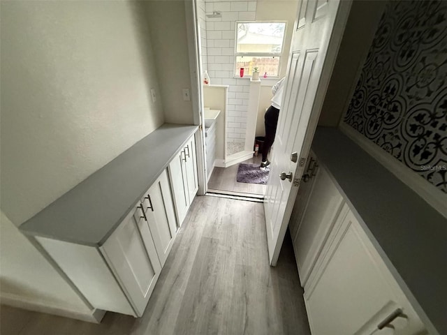 hall featuring tile walls and light wood-type flooring