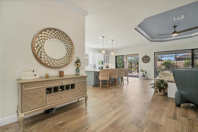 interior space featuring ornamental molding, ceiling fan, and light hardwood / wood-style flooring