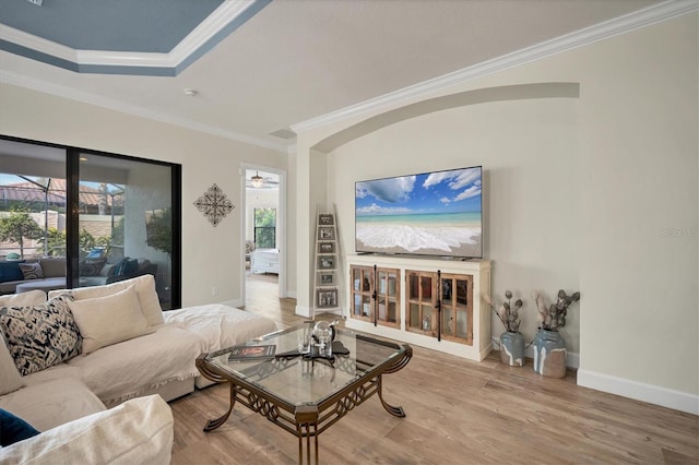 living room with hardwood / wood-style floors, ornamental molding, and ceiling fan