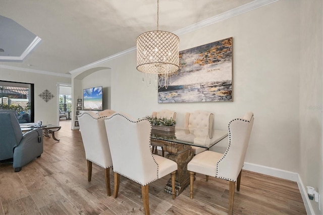 dining room featuring ornamental molding, hardwood / wood-style floors, and an inviting chandelier