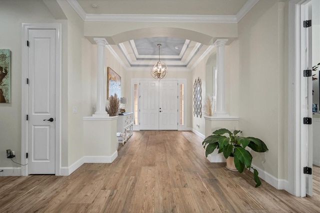 entryway with ornamental molding, light wood-type flooring, and ornate columns