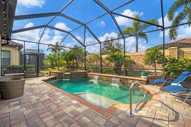 view of pool featuring a patio, an in ground hot tub, pool water feature, and glass enclosure