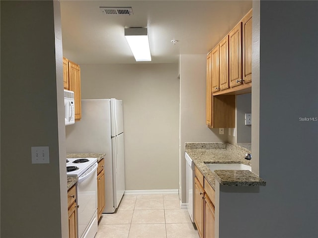 kitchen featuring sink, white appliances, light tile patterned floors, and stone counters