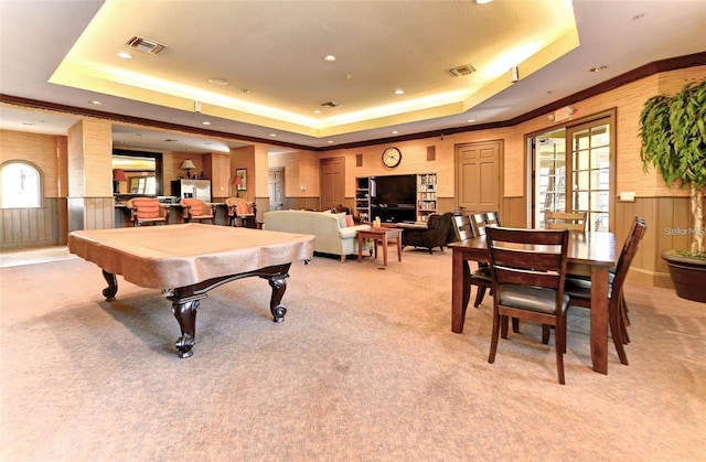 rec room featuring light colored carpet and a tray ceiling