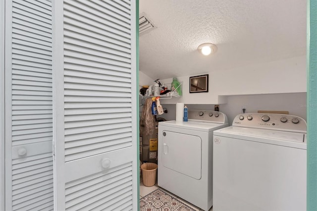 laundry area featuring washer and clothes dryer and a textured ceiling