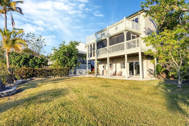 back of house with a patio area, a sunroom, a balcony, and a lawn