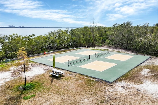 view of basketball court featuring tennis court and a water view