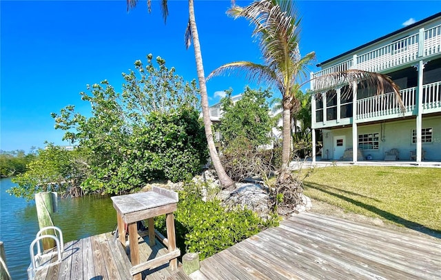 view of dock featuring a lawn and a water view