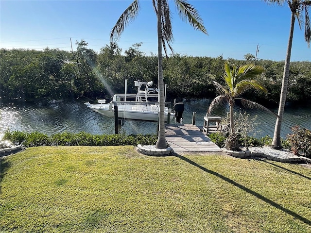 view of dock featuring a lawn and a water view