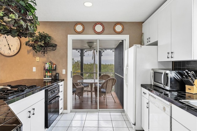 kitchen featuring light tile patterned flooring, tasteful backsplash, tile counters, stainless steel appliances, and white cabinets