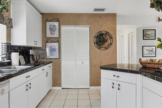 kitchen with white cabinetry, sink, tile counters, light tile patterned floors, and white dishwasher