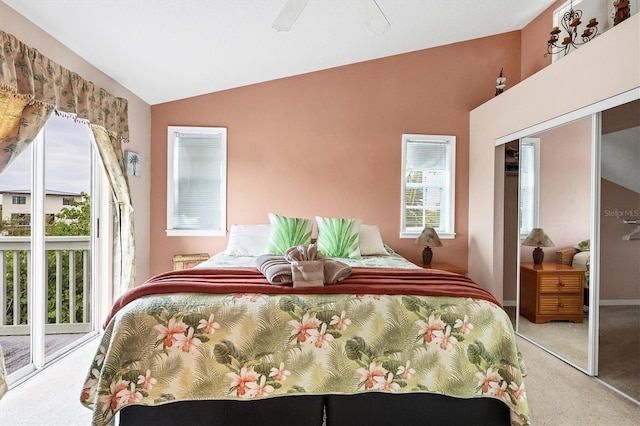 carpeted bedroom featuring multiple windows, vaulted ceiling, ceiling fan, and a closet