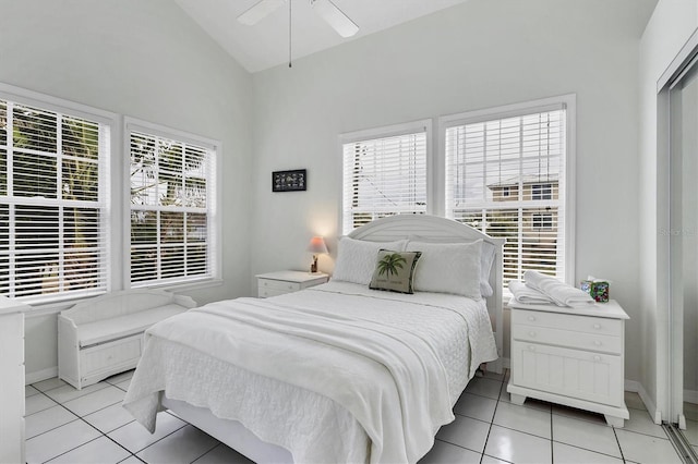 bedroom featuring multiple windows, vaulted ceiling, and light tile patterned flooring