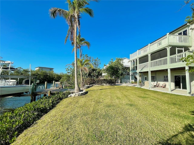 view of yard with a water view and a dock