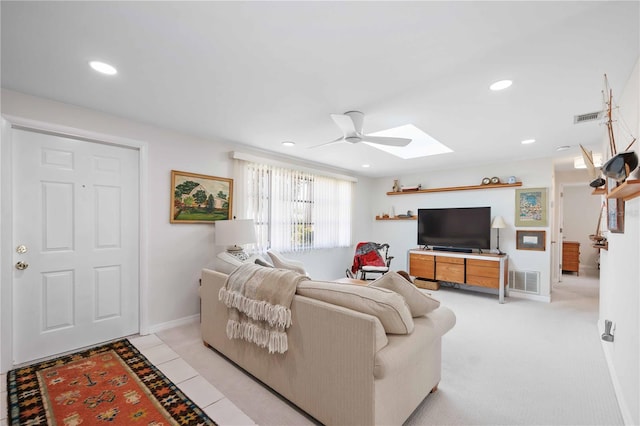 living room with a skylight and ceiling fan