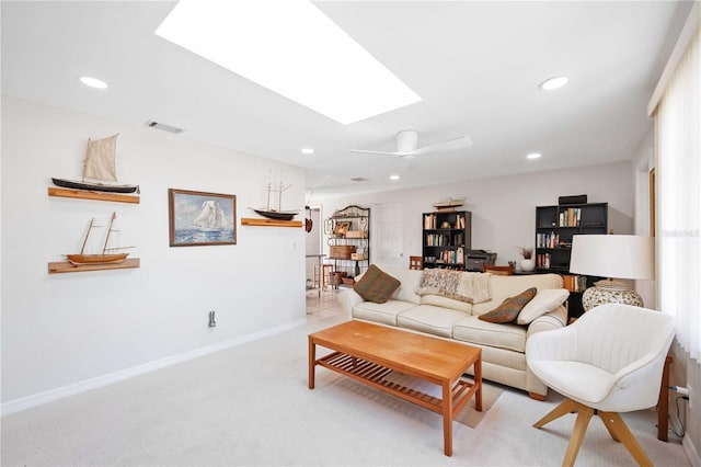 carpeted living room featuring a skylight and ceiling fan