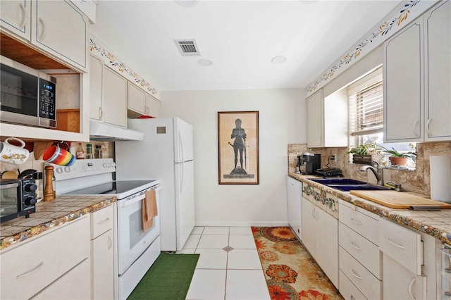 kitchen featuring sink, white cabinets, white appliances, and decorative backsplash