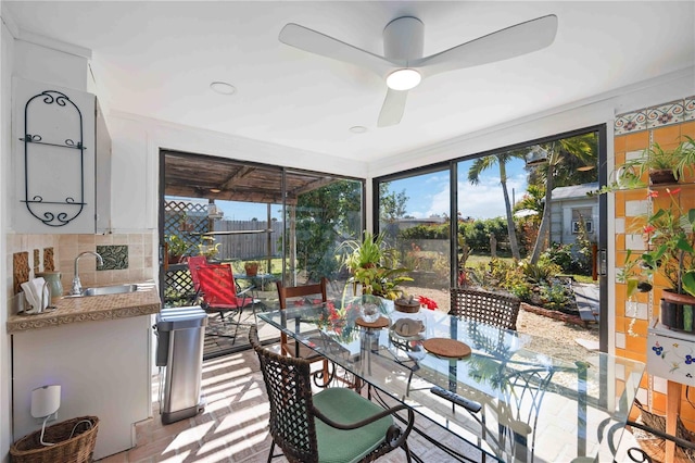 sunroom / solarium featuring plenty of natural light, sink, and ceiling fan