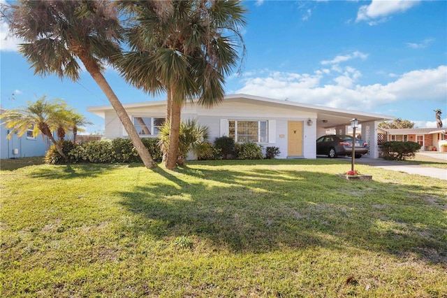 ranch-style home featuring concrete driveway, a carport, and a front yard